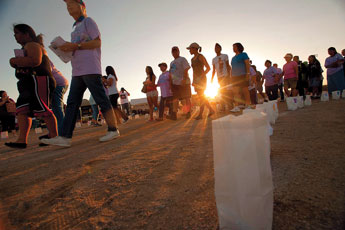 Cancer survivors and their supporters walk at sunset for the survivors lap at the start of the 2011 Gallup Relay for Life on Friday. © 2011 Gallup Independent / Adron Gardner 